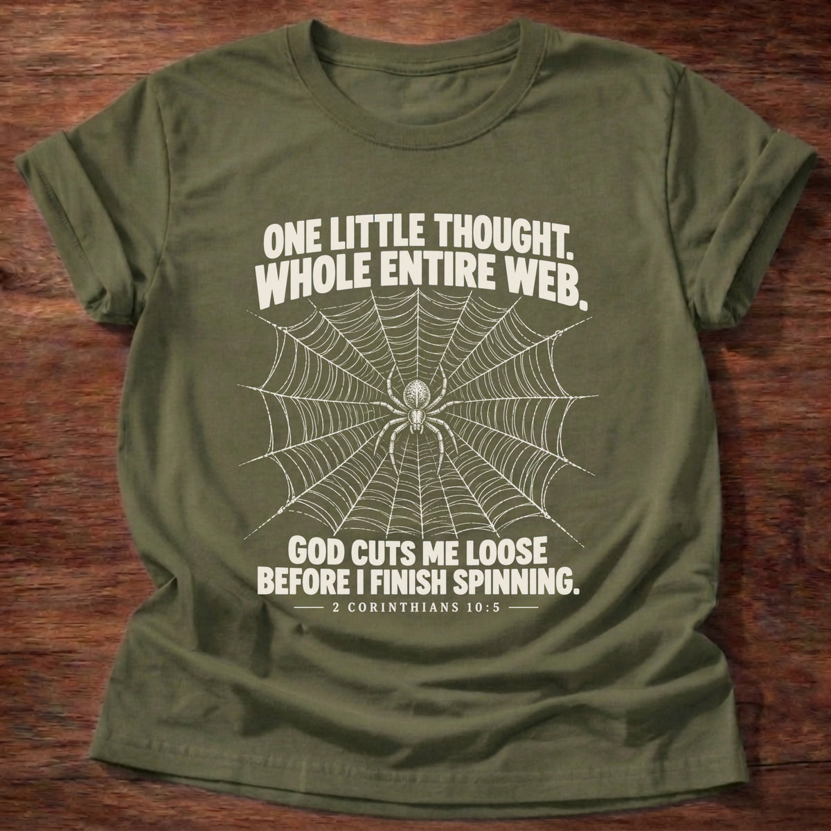Military Green t-shirt printed with a spider at the center of its web graphic and 'One little thought. Whole entire web. God cuts me loose before I finish spinning.' 2 Corinthians 10:5 faith based gift