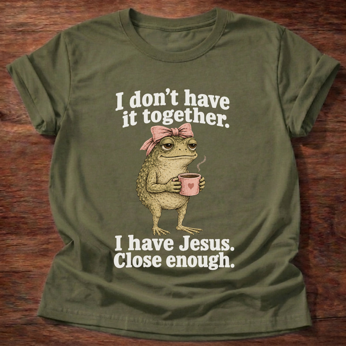 Military Green t-shirt printed with a frog holding a tea cup graphic and 'I don't have it together. I have Jesus. Close enough.' 2 Corinthians 12:9 faith based gift
