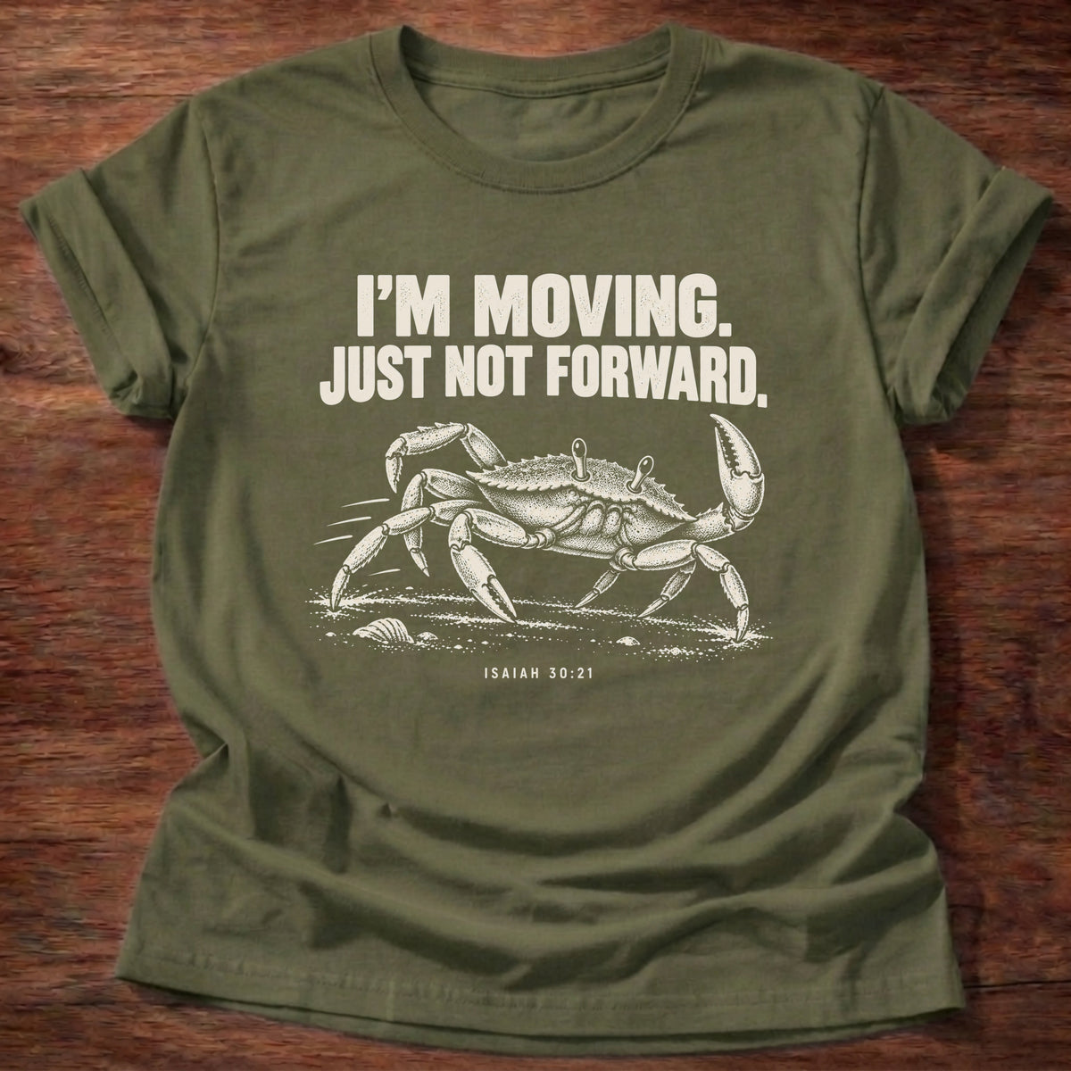 Military Green t-shirt printed with a crab scuttling sideways across the sand graphic and 'I'm moving. Just not forward.' Isaiah 30:21 faith based gift