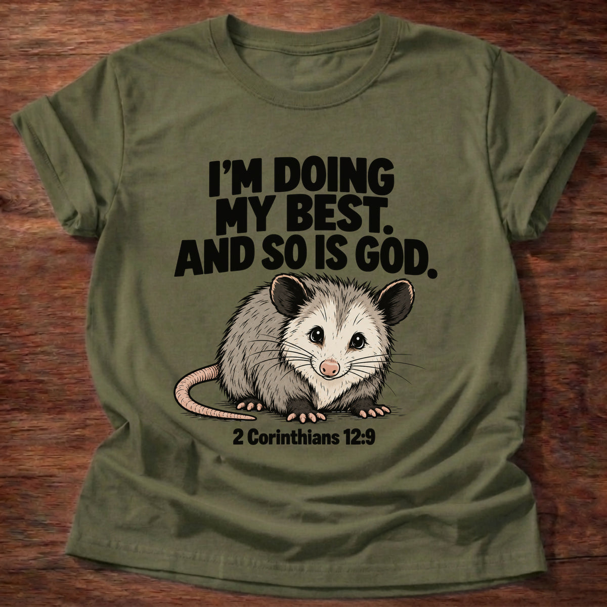 Military Green t-shirt printed with an opossum graphic and 'I'm doing my best. And so is God.' 2 Corinthians 12:9 faith based gift