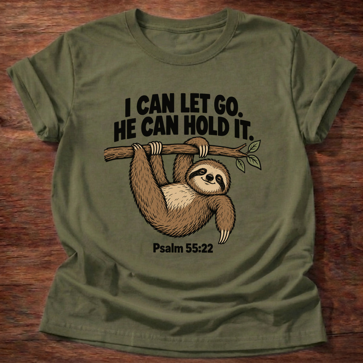 Military Green t-shirt printed with a sloth hanging from a branch graphic and 'I can let go. He can hold it.' Psalm 55:22 faith based gift