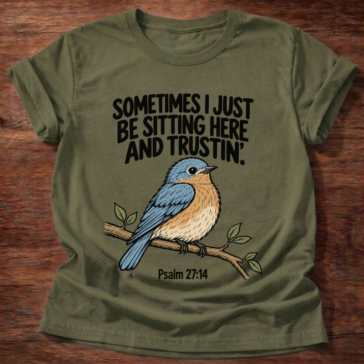Military Green t-shirt printed with a bluebird on a branch graphic and 'Sometimes I just be sitting here and trustin'.' Psalm 27:14 faith based gift
