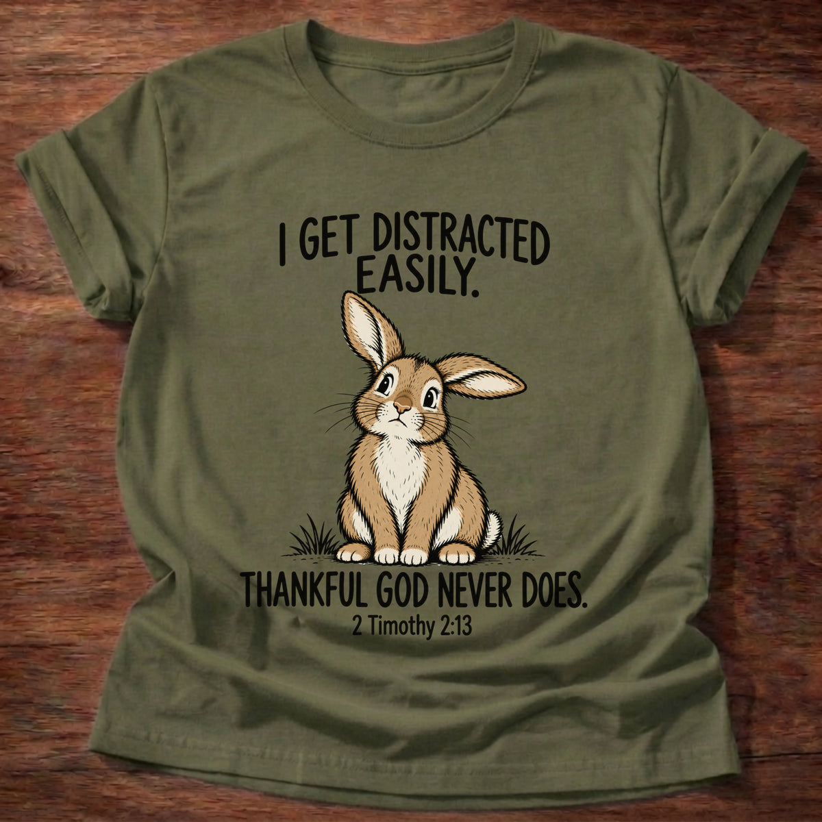 Military Green t-shirt printed with a rabbit graphic and 'I get distracted easily. Thankful God never does.' 2 Timothy 2:13 faith based gift
