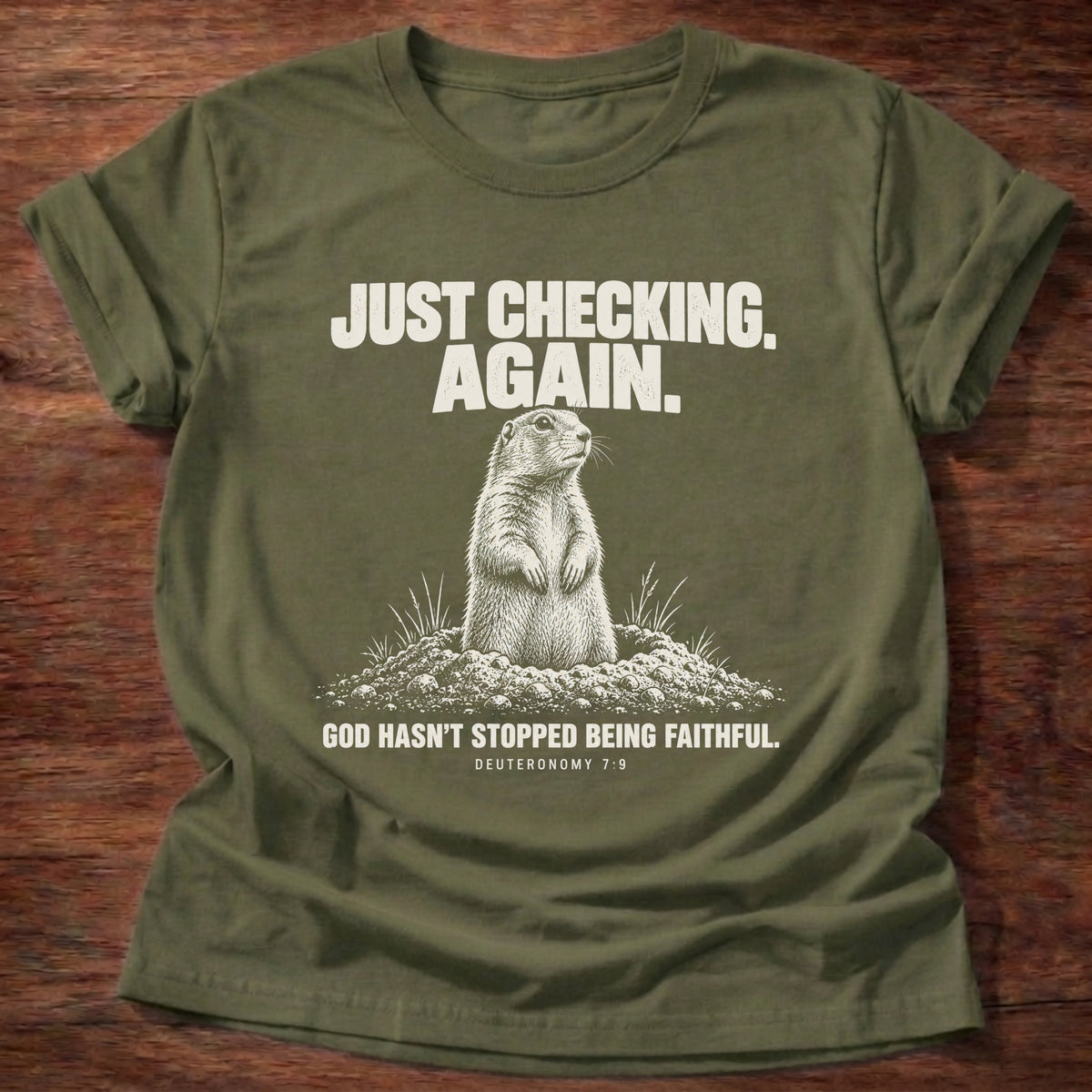 Military Green t-shirt printed with a prairie dog popping up out of its burrow graphic and 'Just checking. Again. God hasn't stopped being faithful.' Deuteronomy 7:9 faith based gift