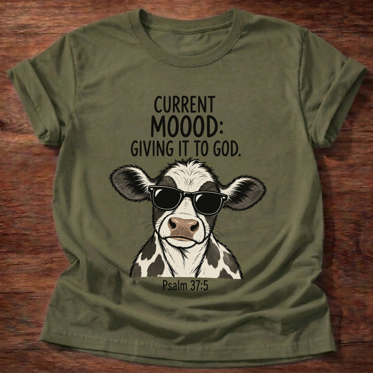 Military Green t-shirt printed with a sunglasses-wearing cow graphic and 'Current moood: giving it to God.' Psalm 55:22 faith based gift
