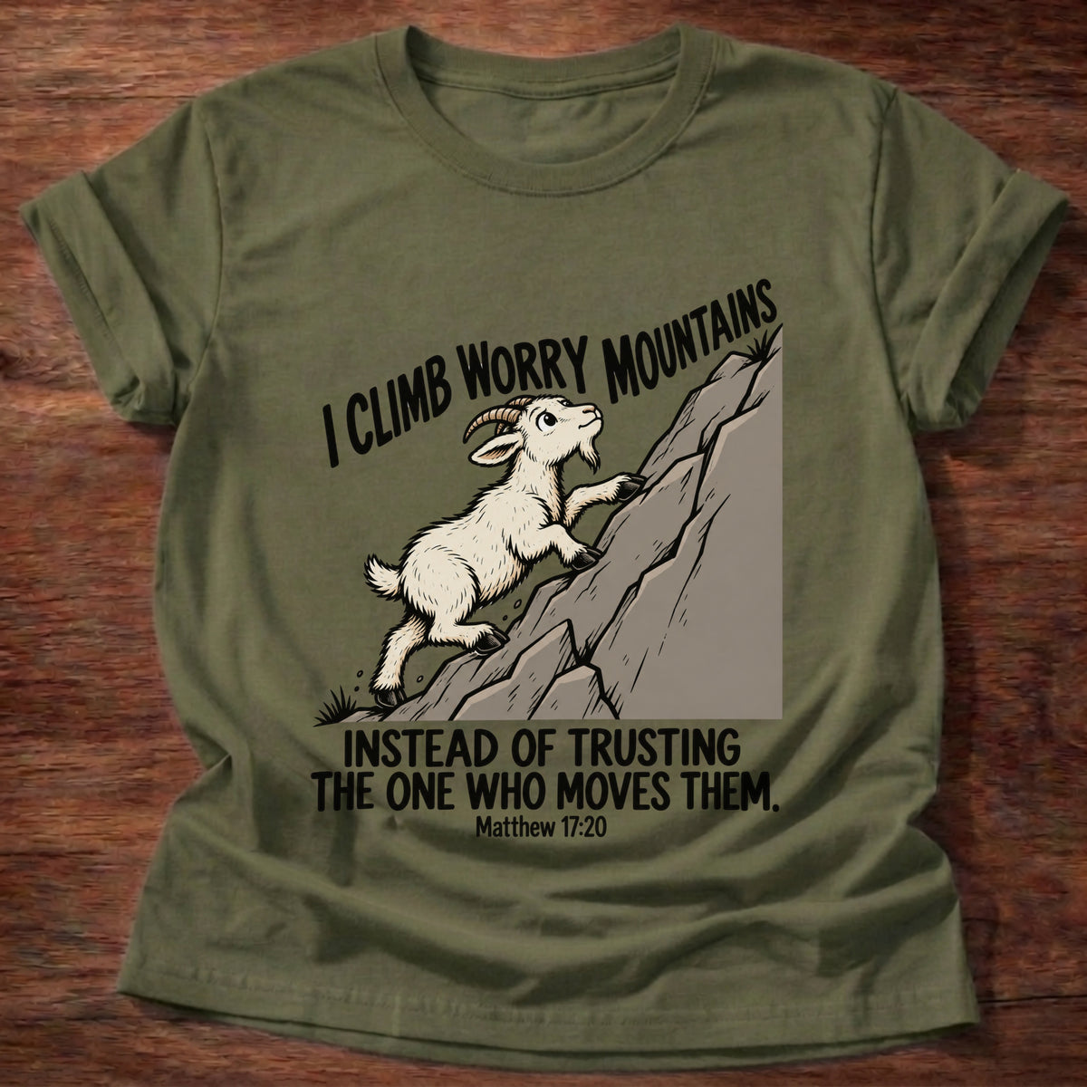 Military Green t-shirt printed with a goat climbing a mountain graphic and 'I climb worry mountains instead of trusting the One who moves them.' Matthew 17:20 faith based gift