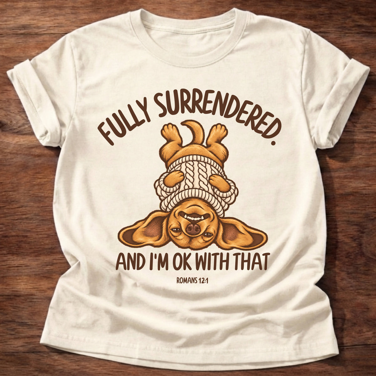 Natural t-shirt printed with an upside-down puppy in a cozy sweater and “Fully surrendered. And I'm OK with that.” Romans 12:1 Christian shirt