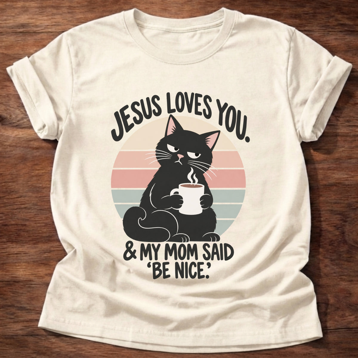 Natural t-shirt printed with a grumpy black cat holding a steaming coffee mug in front of a retro striped sunset graphic and “Jesus loves you. & my mom said 'be nice.'” faith based gift