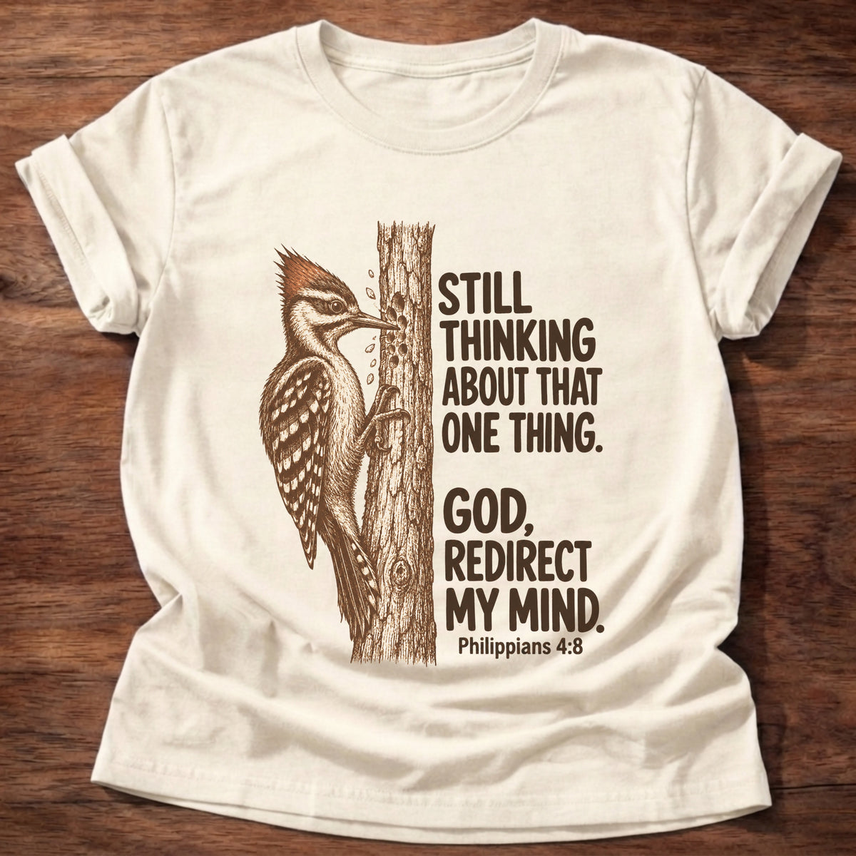 Natural t-shirt printed with a woodpecker pecking at a tree trunk graphic and “Still thinking about that one thing. God, redirect my mind.” Philippians 4:8 faith based gift