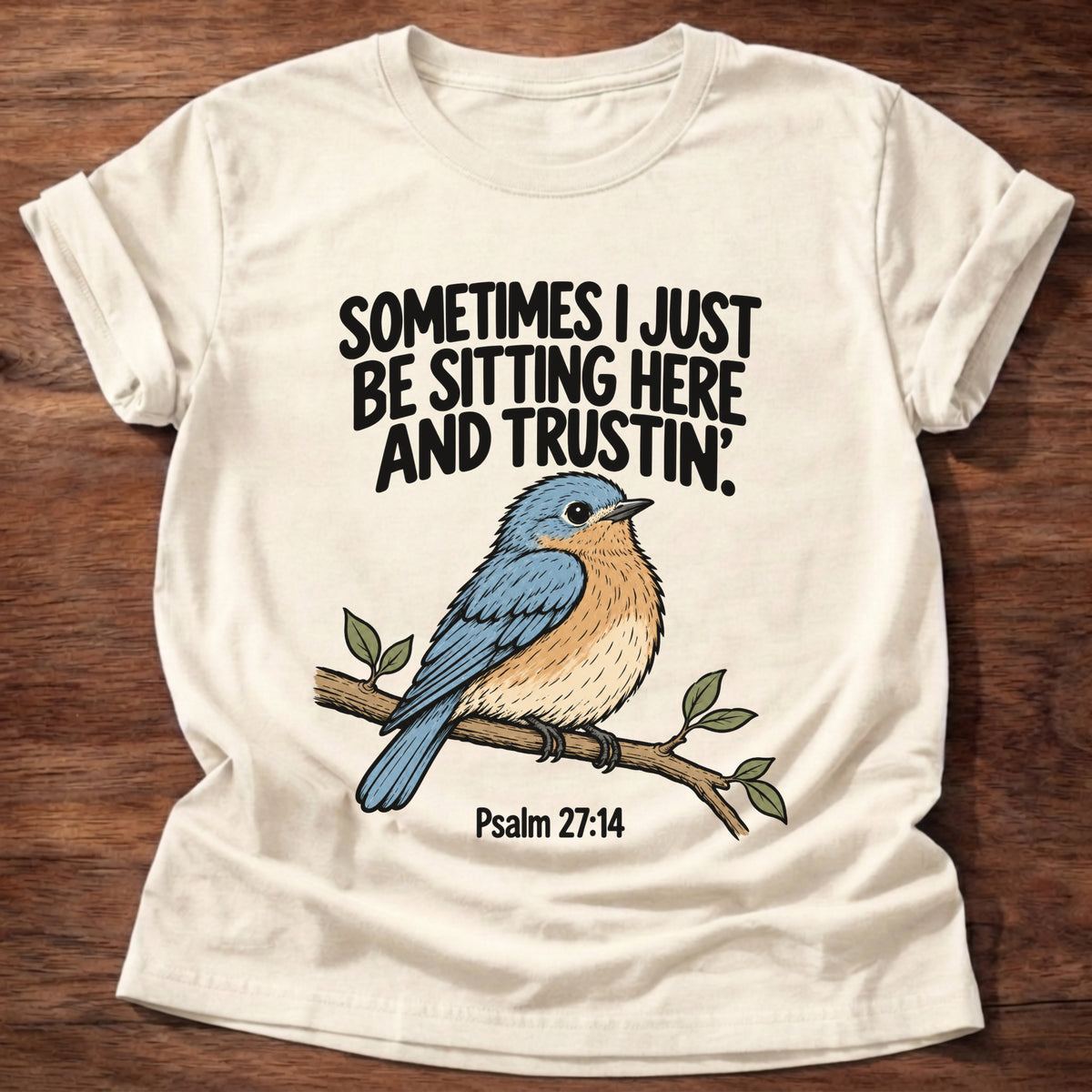 Natural t-shirt printed with a bluebird on a branch graphic and 'Sometimes I just be sitting here and trustin'.' Psalm 27:14 faith based gift