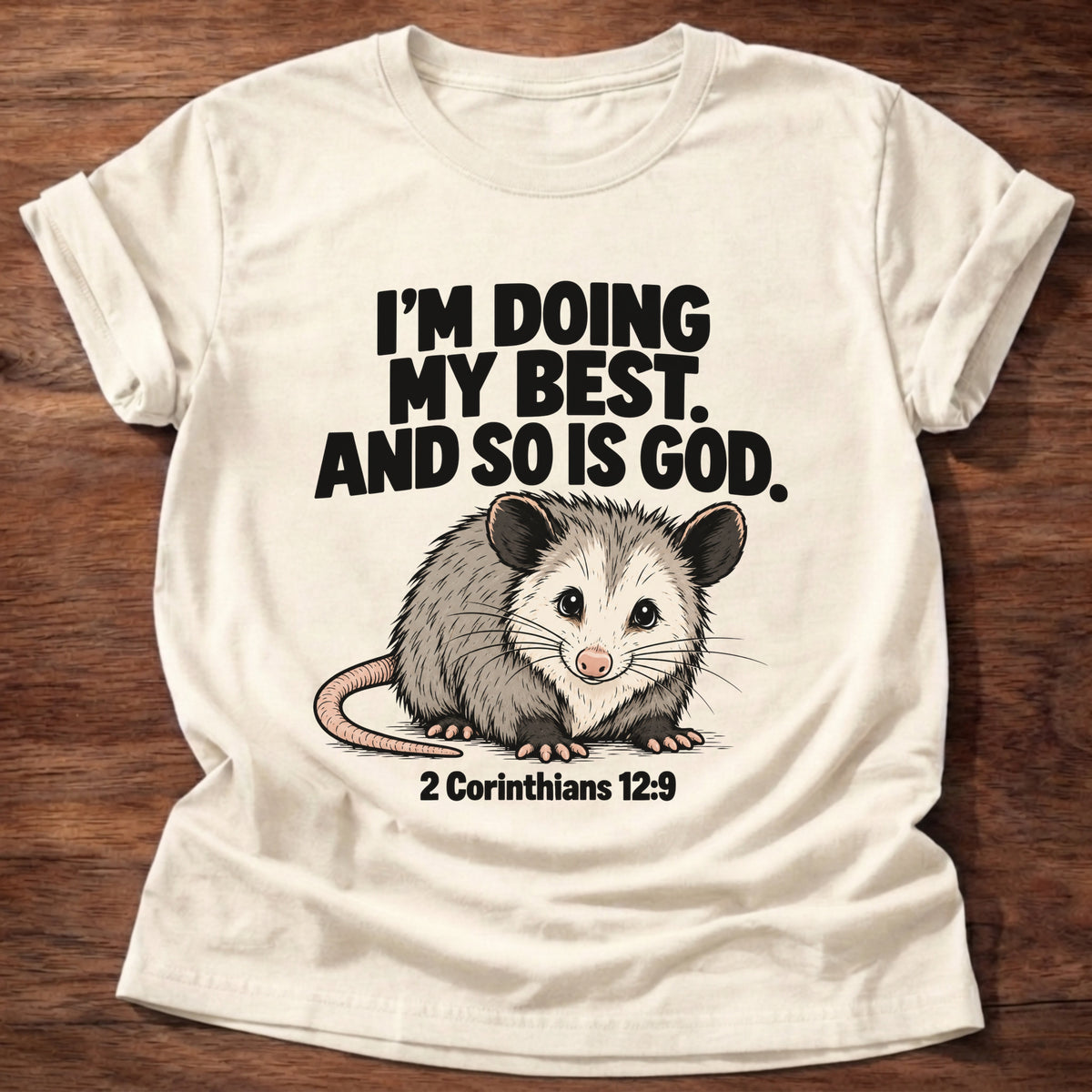 Natural t-shirt printed with an opossum graphic and 'I'm doing my best. And so is God.' 2 Corinthians 12:9 faith based gift