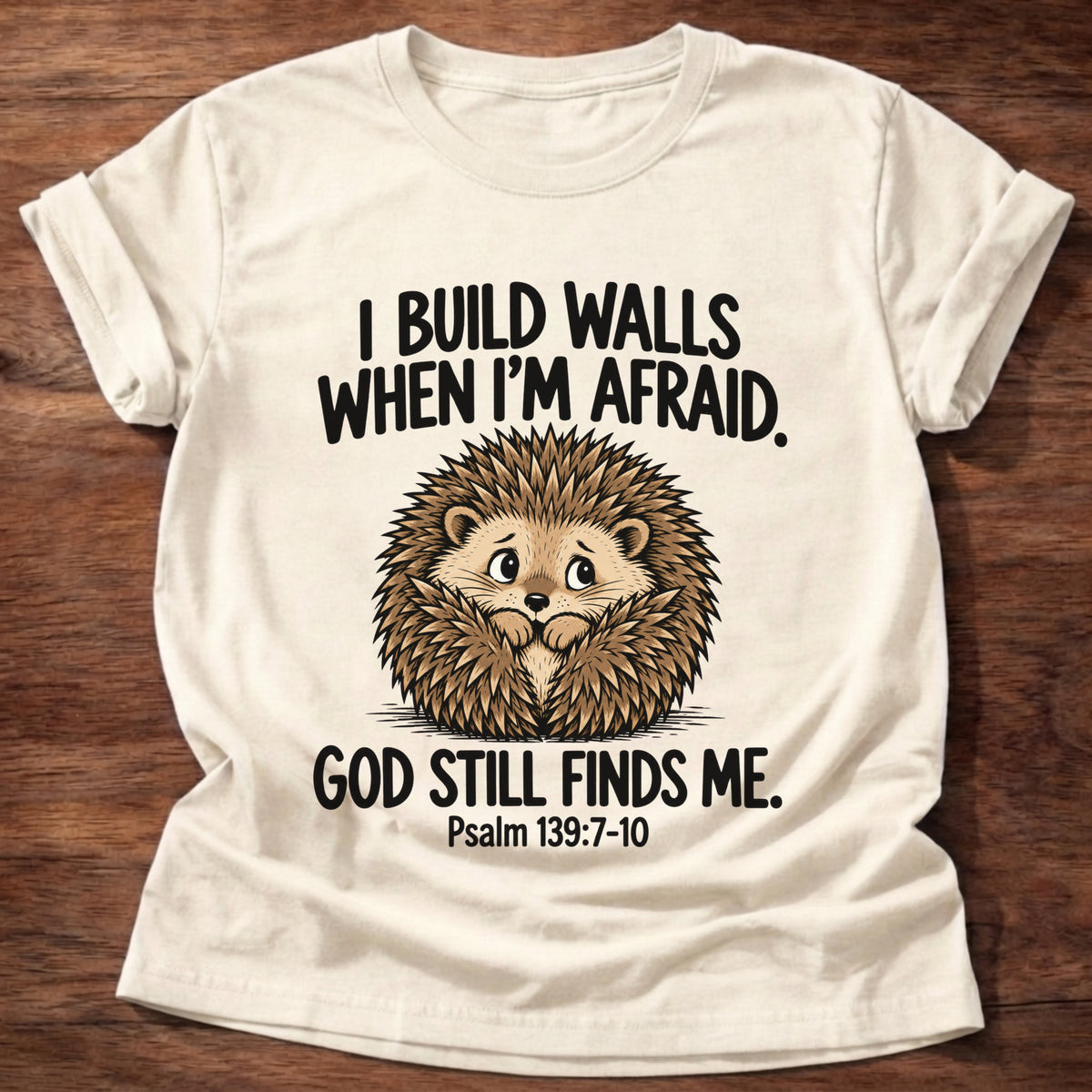 Natural t-shirt printed with a hedgehog curled into a ball and 'I build walls when I'm afraid. God still finds me.' Psalm 139:7-10 faith based gift