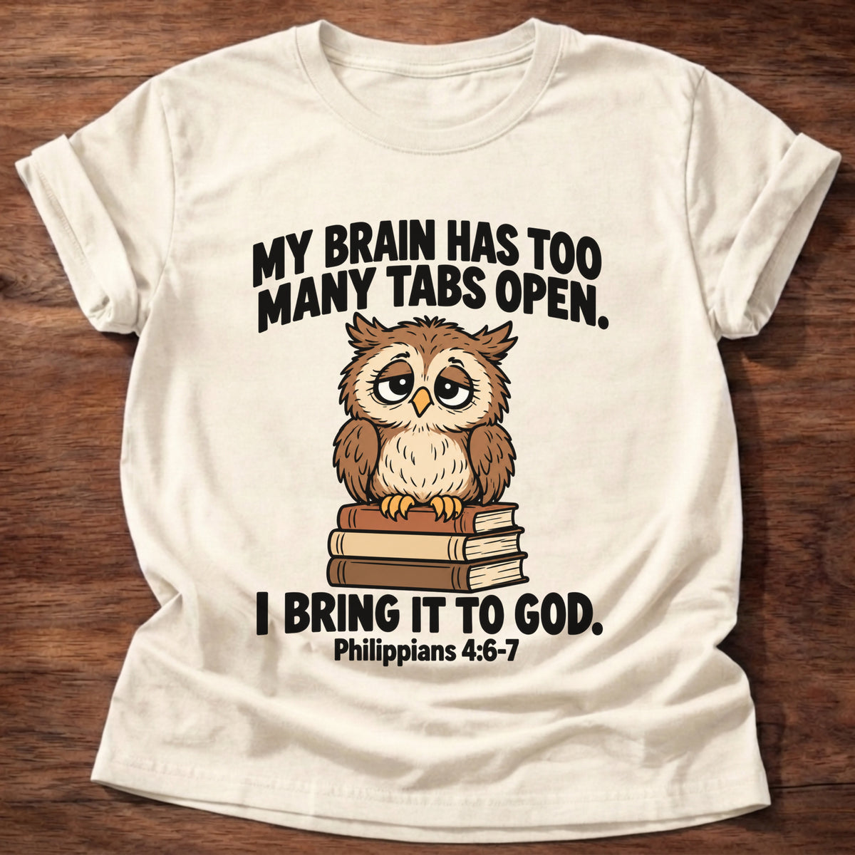 Natural t-shirt printed with an owl surrounded by books graphic and 'My brain has too many tabs open. I bring it to God.' Philippians 4:6-7 faith based gift