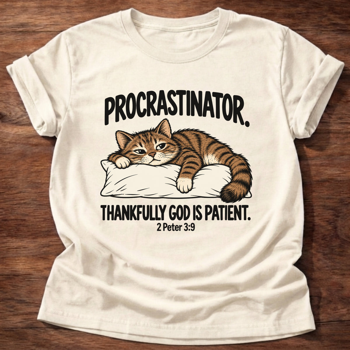 Natural t-shirt printed with a cat sleeping on a pillow graphic and 'Procrastinator. Thankfully God is patient.' 2 Peter 3:9 faith based gift