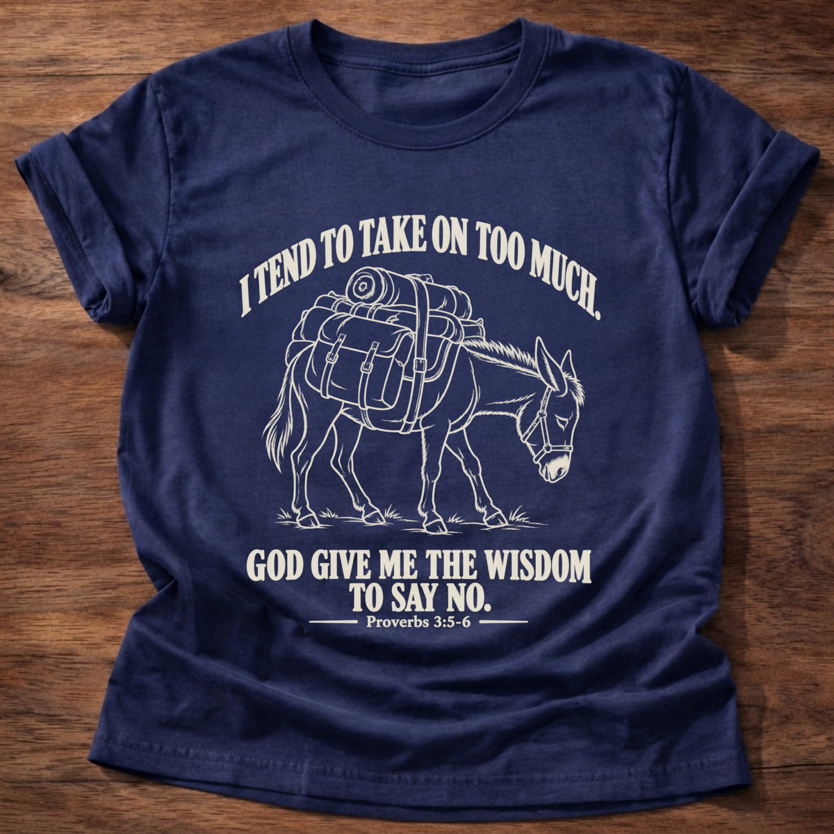 Navy t-shirt printed with a pack donkey weighed down with overstuffed bags and bundles graphic and “I tend to take on too much. God give me the wisdom to say no.” Proverbs 3:5-6 faith based gift