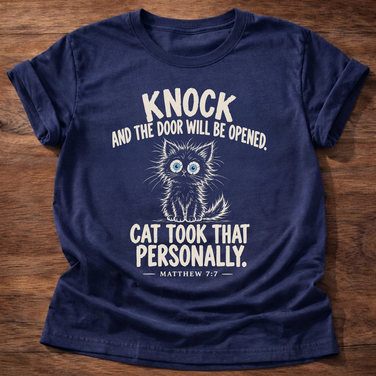 Knock T-Shirt in Navy featuring a wide-eyed fluffy kitten and Matthew 7:7 cat humor design