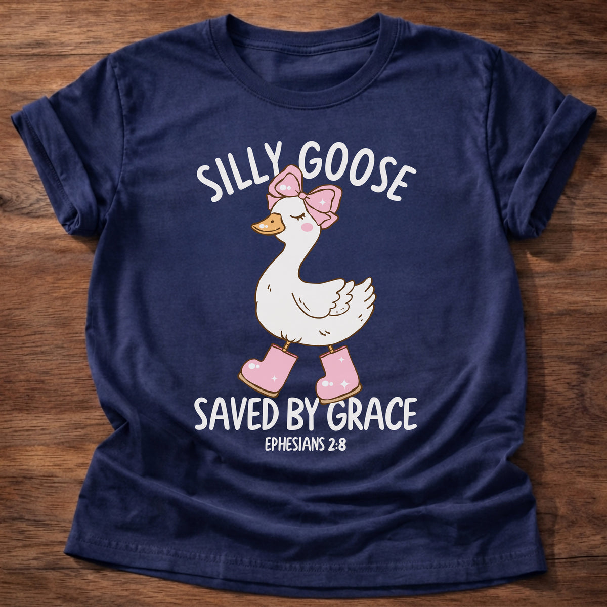 Navy t-shirt printed with a goose wearing a pink bow and pink boots and “Silly Goose. Saved by Grace.” Ephesians 2:8 Christian shirt