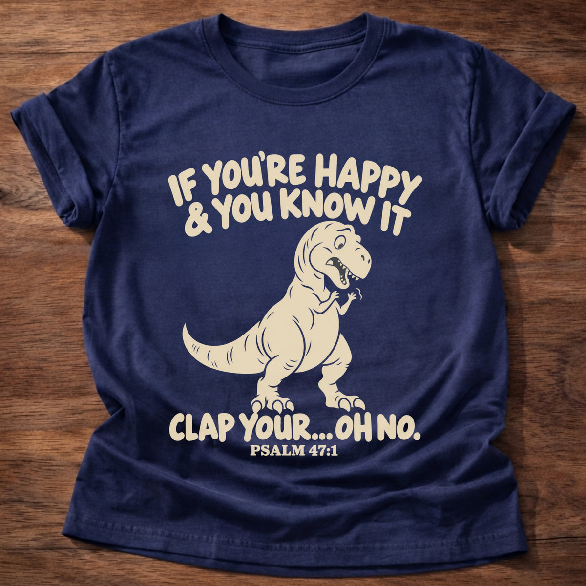 Navy t-shirt printed with a T-rex with tiny arms graphic and “If you're happy & you know it clap your... oh no.” Psalm 47:1 Christian shirt