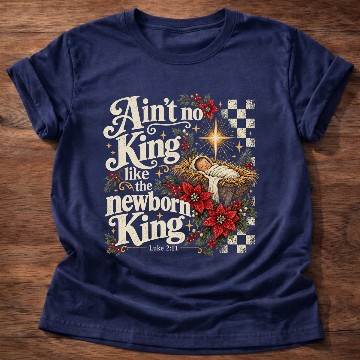 Navy t-shirt printed with a retro manger scene with a star, poinsettias and checkerboard graphic and “Ain't no King like the newborn King.” Luke 2:11 Christian shirt