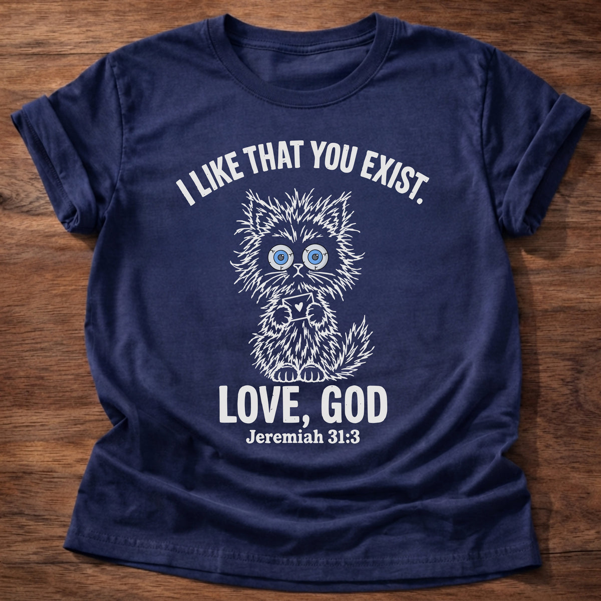 Navy t-shirt printed with a fluffy wide-eyed kitten graphic and “I like that you exist. Love, God.” Jeremiah 31:3 Christian shirt