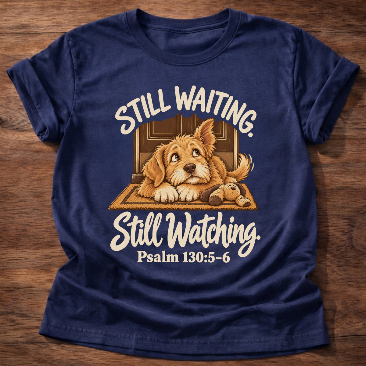 Navy t-shirt printed with a puppy lying on a doormat waiting at the door and “Still waiting. Still watching.” Psalm 130:5-6 Christian shirt