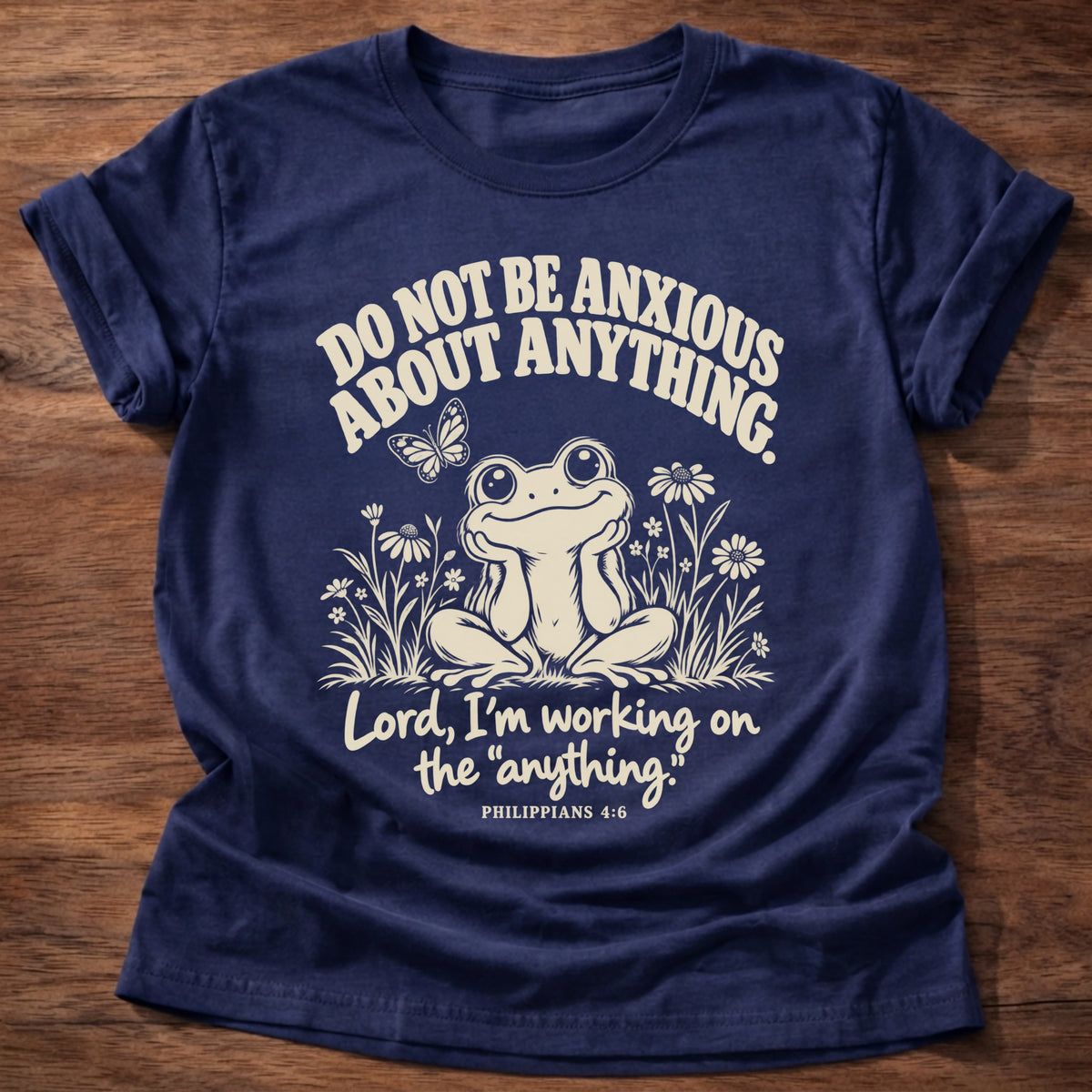 Anything Part T-Shirt in Navy featuring a wide-eyed frog sitting among wildflowers and Philippians 4:6 anxiety humor design