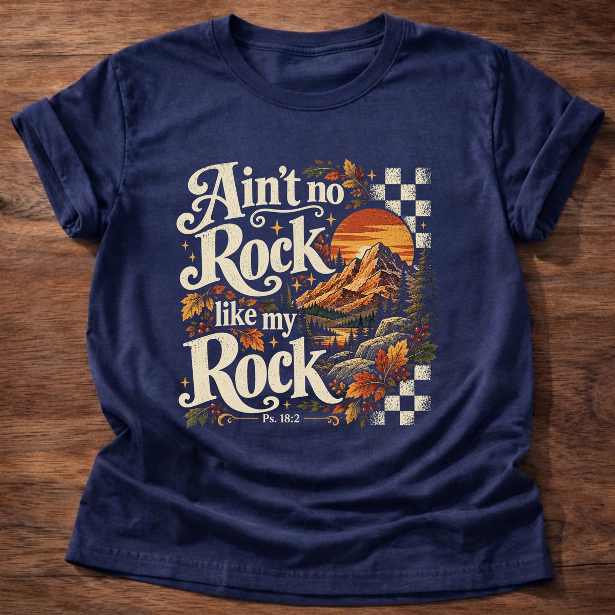 Navy t-shirt printed with a retro mountain sunset with autumn leaves and checkerboard graphic and “Ain't no Rock like my Rock.” Psalm 18:2 Christian shirt