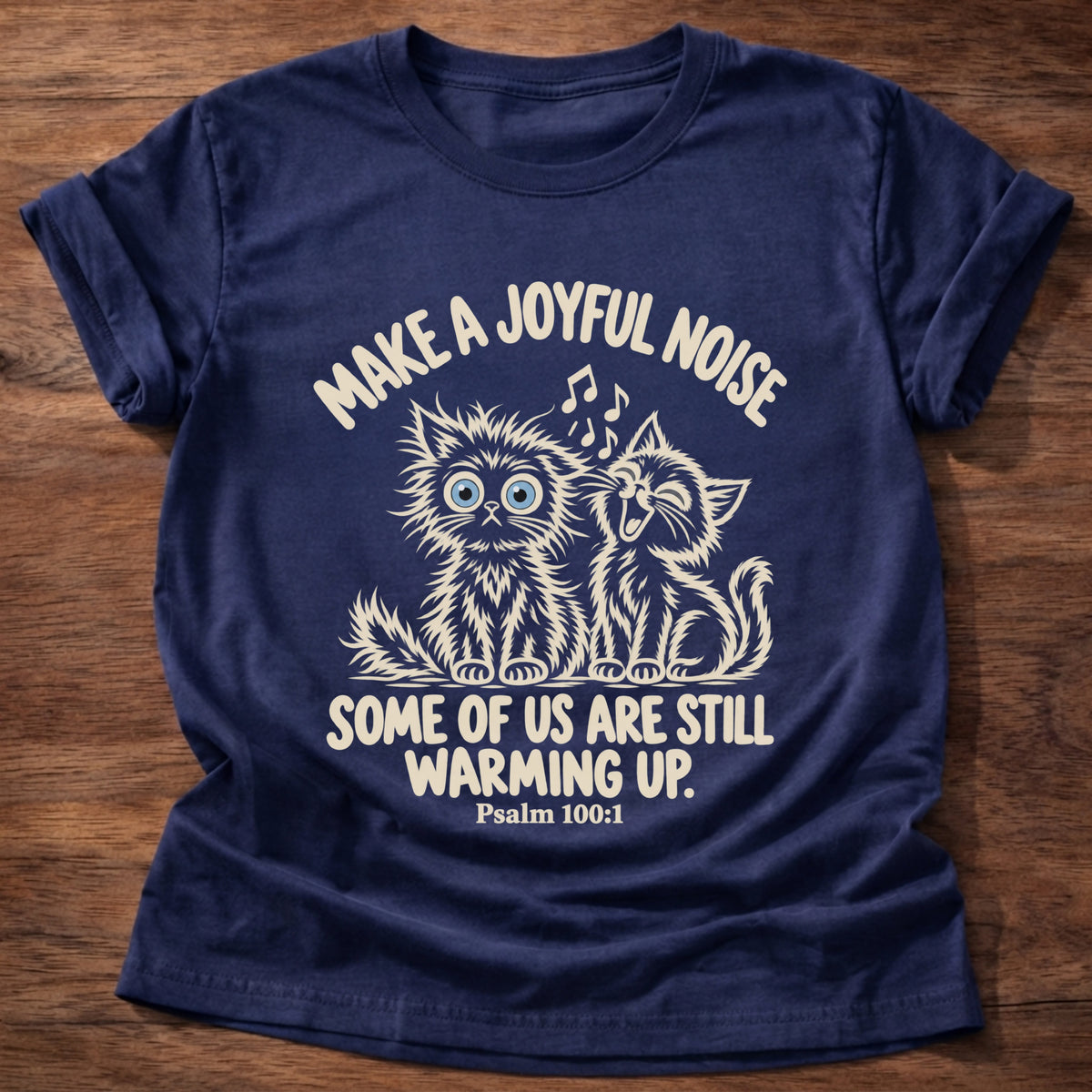Navy t-shirt printed with two fluffy kittens singing graphic and “Make a joyful noise. Some of us are still warming up.” Psalm 100:1 Christian shirt