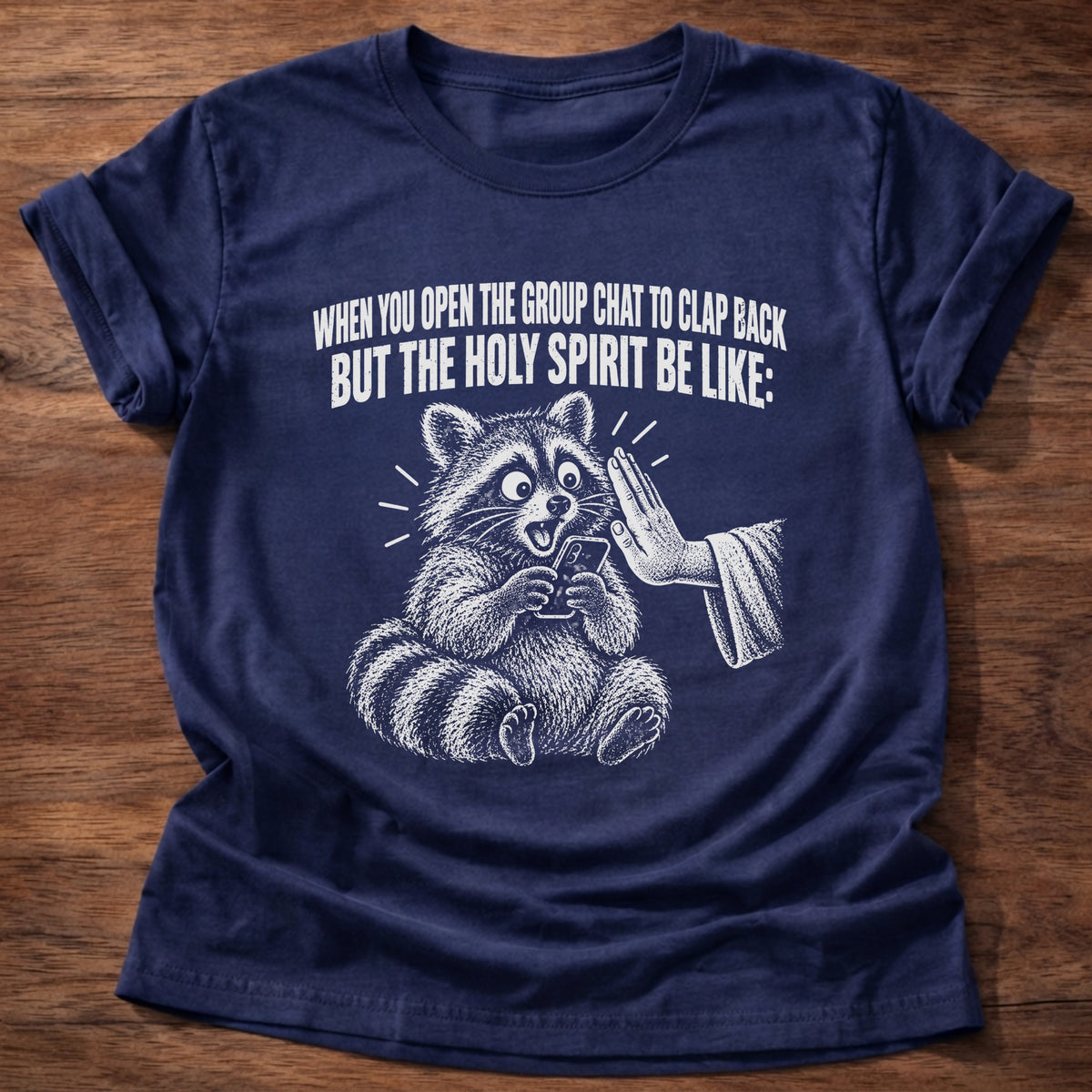 Navy t-shirt printed with a raccoon covering its own mouth graphic and 'When you open the group chat to clap back but the Holy Spirit be like.' Proverbs 21:23 faith based gift