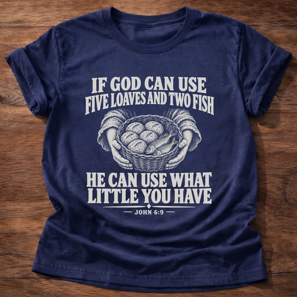 Navy t-shirt printed with a basket of loaves and fish graphic and 'If God can use five loaves and two fish, He can use what little you have.' John 6:9 faith based gift