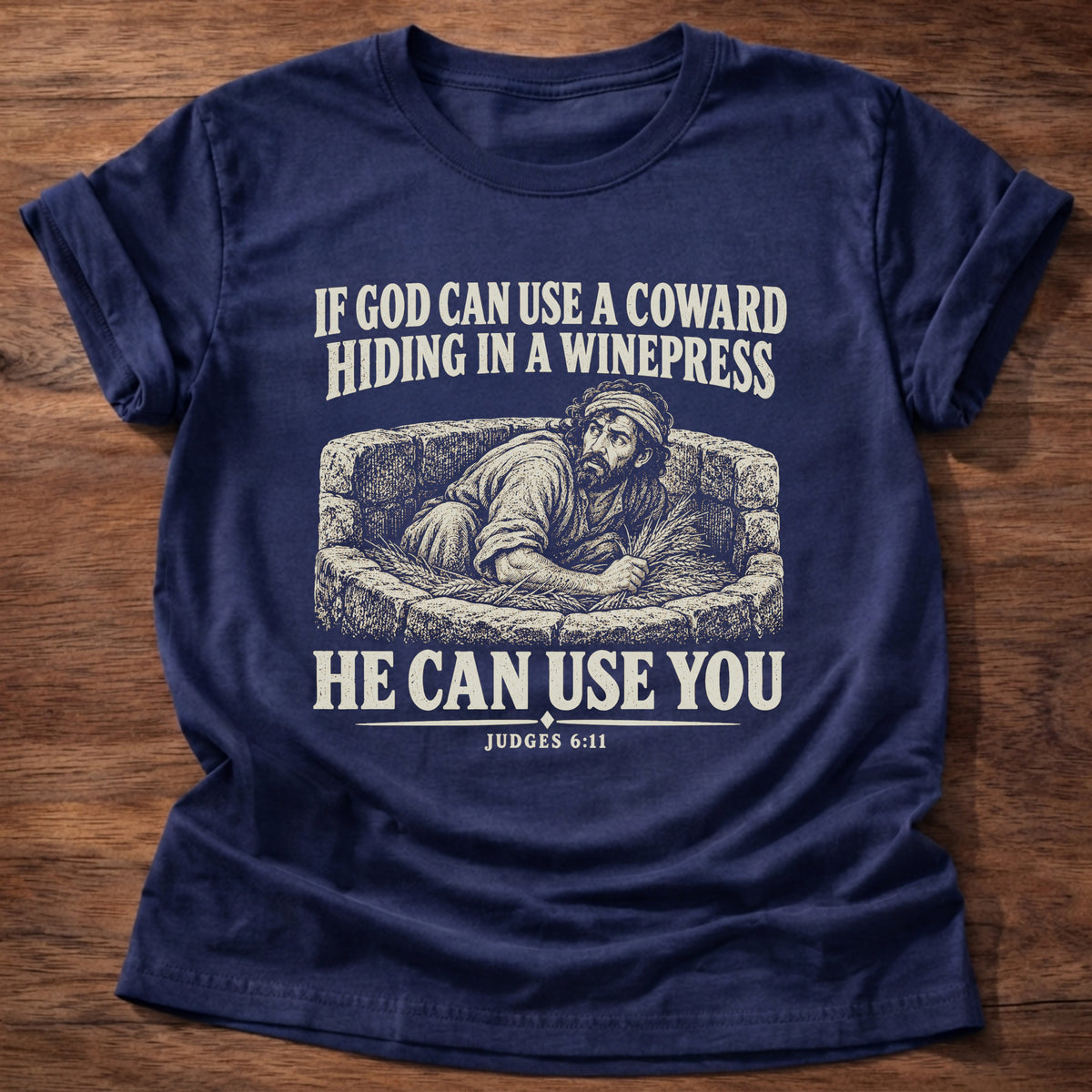 Navy t-shirt printed with Gideon hiding in a winepress graphic and 'If God can use a coward hiding in a winepress, He can use you.' Judges 6:11 faith based gift