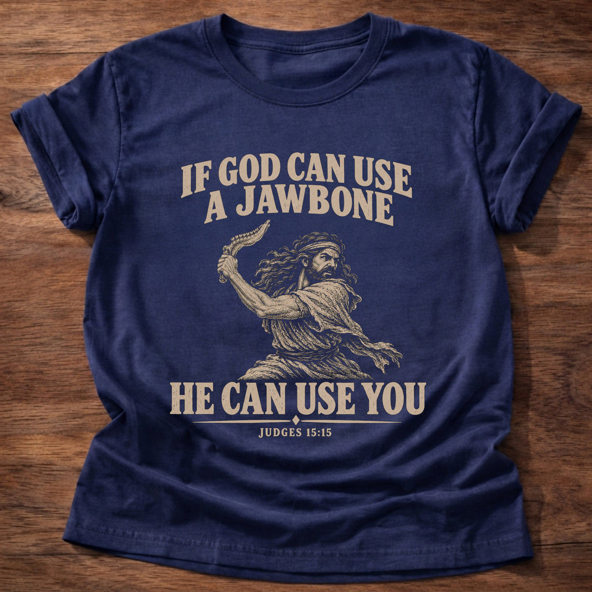 Navy t-shirt printed with Samson holding a jawbone graphic and 'If God can use a jawbone, He can use you.' Judges 15:15 faith based gift