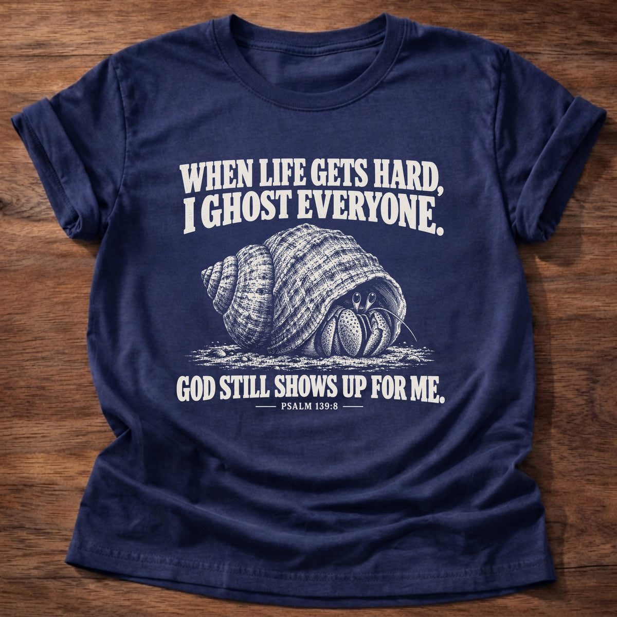 Navy t-shirt printed with a hermit crab retreating into its shell graphic and 'When life gets hard, I ghost everyone. God still shows up for me.' Psalm 139:8 faith based gift