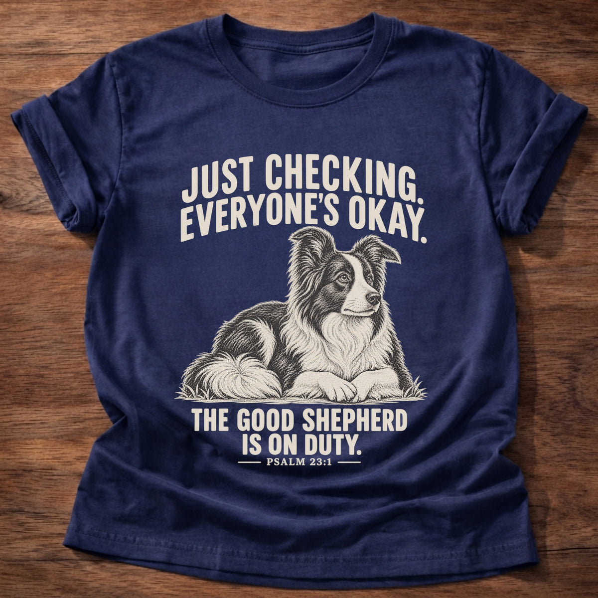 Navy t-shirt printed with a border collie lying watchfully in the grass graphic and 'Just checking. Everyone's okay. The good shepherd is on duty.' Psalm 23:1 faith based gift
