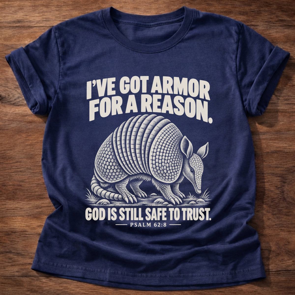 Navy t-shirt printed with an armadillo in full armor graphic and 'I've got armor for a reason. God is still safe to trust.' Psalm 62:8 faith based gift