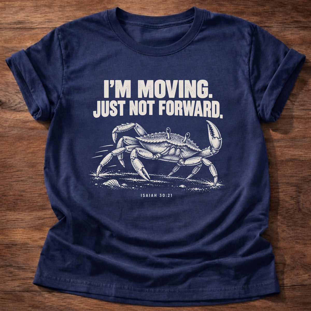 Navy t-shirt printed with a crab scuttling sideways across the sand graphic and 'I'm moving. Just not forward.' Isaiah 30:21 faith based gift