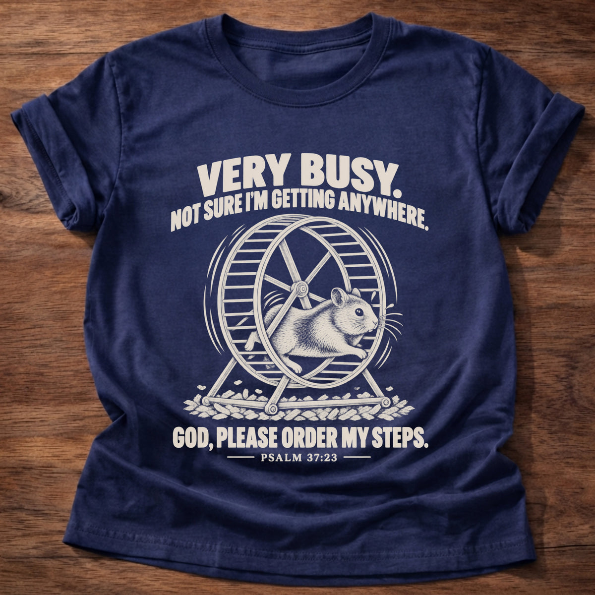 Navy t-shirt printed with a squirrel running on a wheel graphic and 'Very busy. Not sure I'm getting anywhere. God, please order my steps.' Psalm 37:23 faith based gift