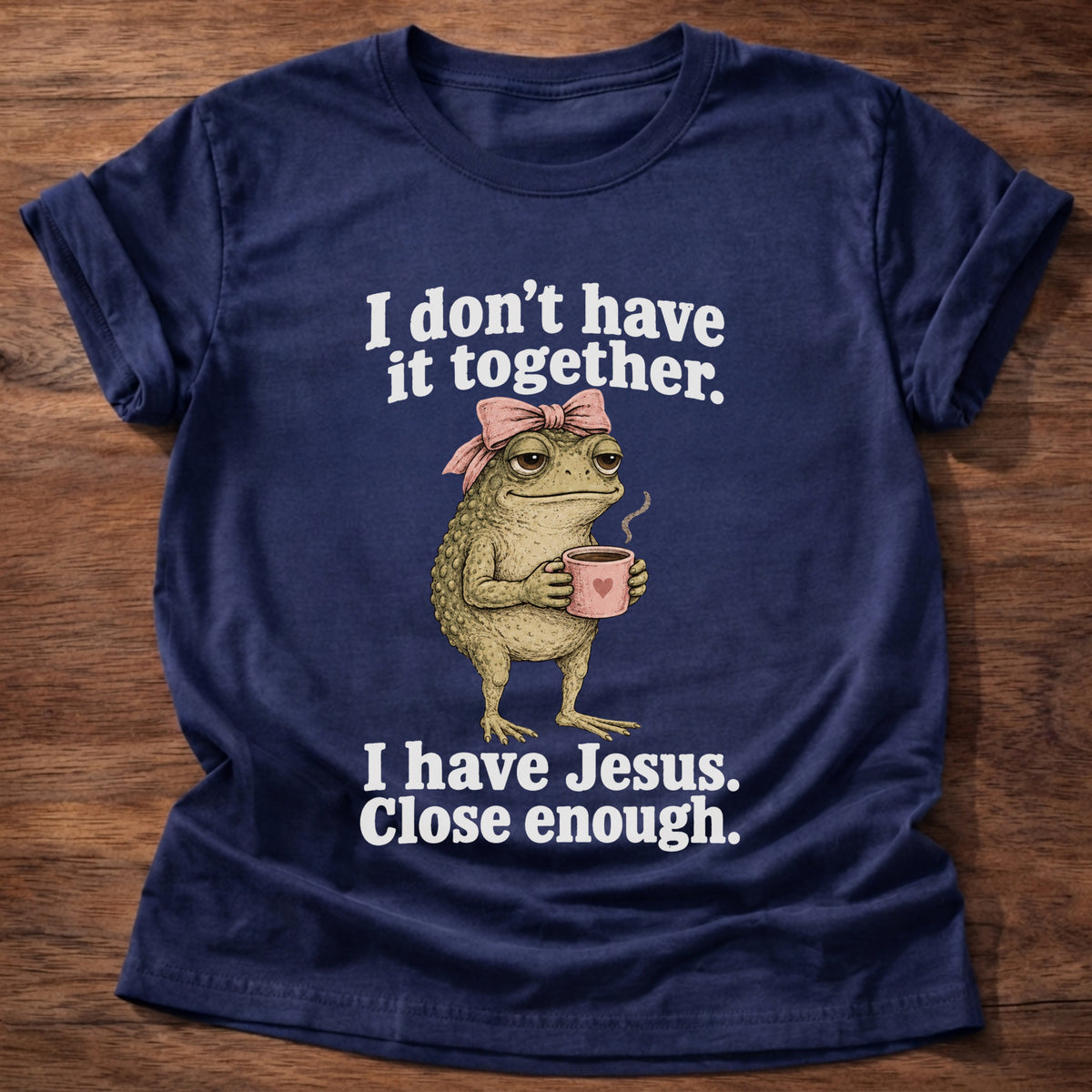 Navy t-shirt printed with a frog holding a tea cup graphic and 'I don't have it together. I have Jesus. Close enough.' 2 Corinthians 12:9 faith based gift