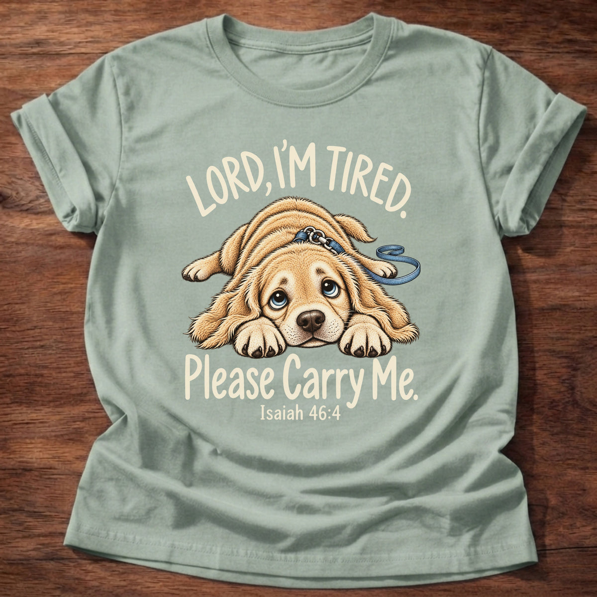 Sage t-shirt printed with a tired puppy lying flat on the floor graphic and “Lord, I'm tired. Please carry me.” Isaiah 46:4 Christian shirt