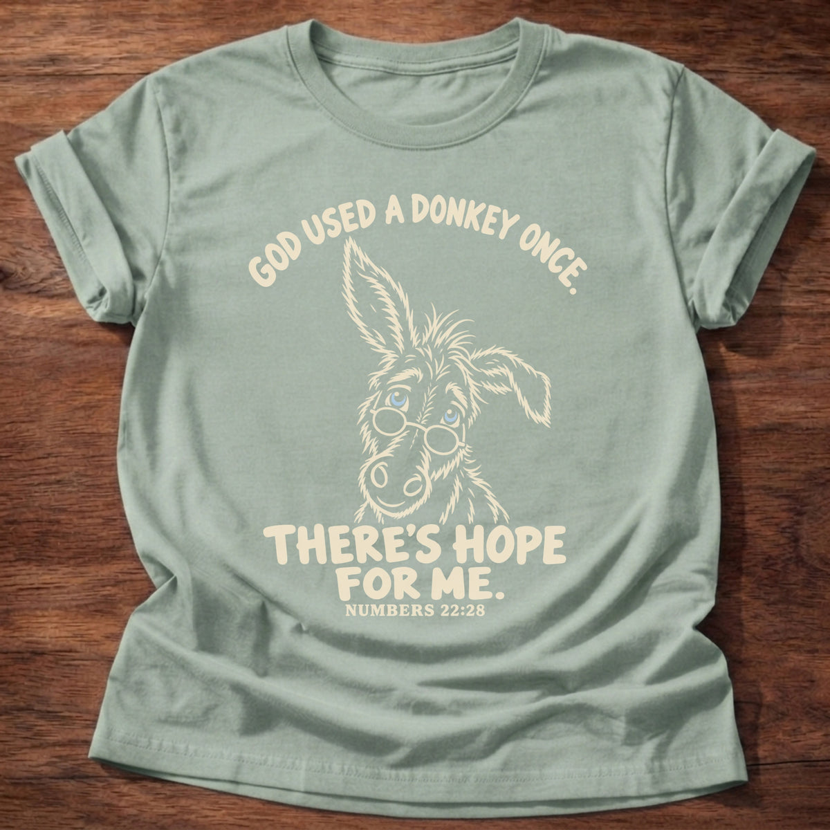 Sage t-shirt printed with a hand-drawn donkey and “God used a donkey once. There's hope for me.” Numbers 22:28 Christian shirt