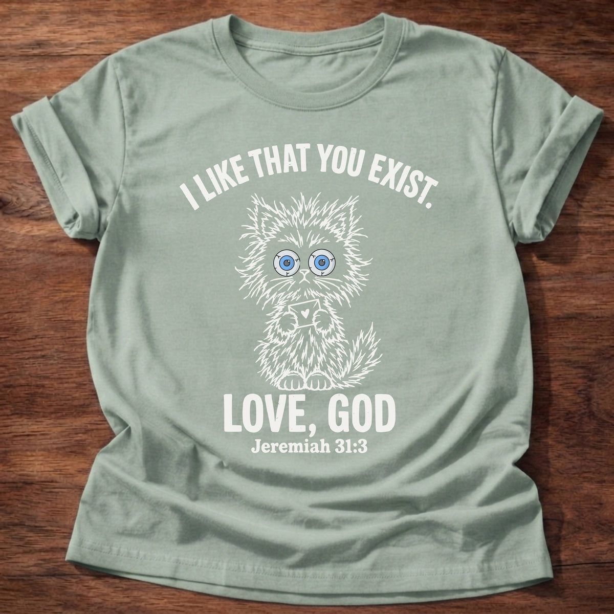 Sage t-shirt printed with a fluffy wide-eyed kitten graphic and “I like that you exist. Love, God.” Jeremiah 31:3 Christian shirt
