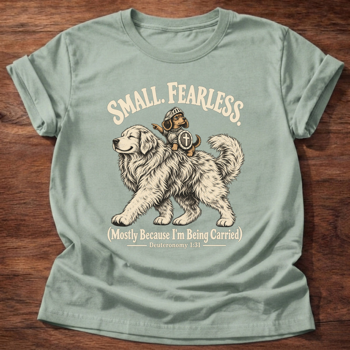 Sage t-shirt printed with a tiny brave rider on a big fluffy dog graphic and “Small. Fearless. (Mostly because I'm being carried.)” Deuteronomy 1:31 Christian shirt