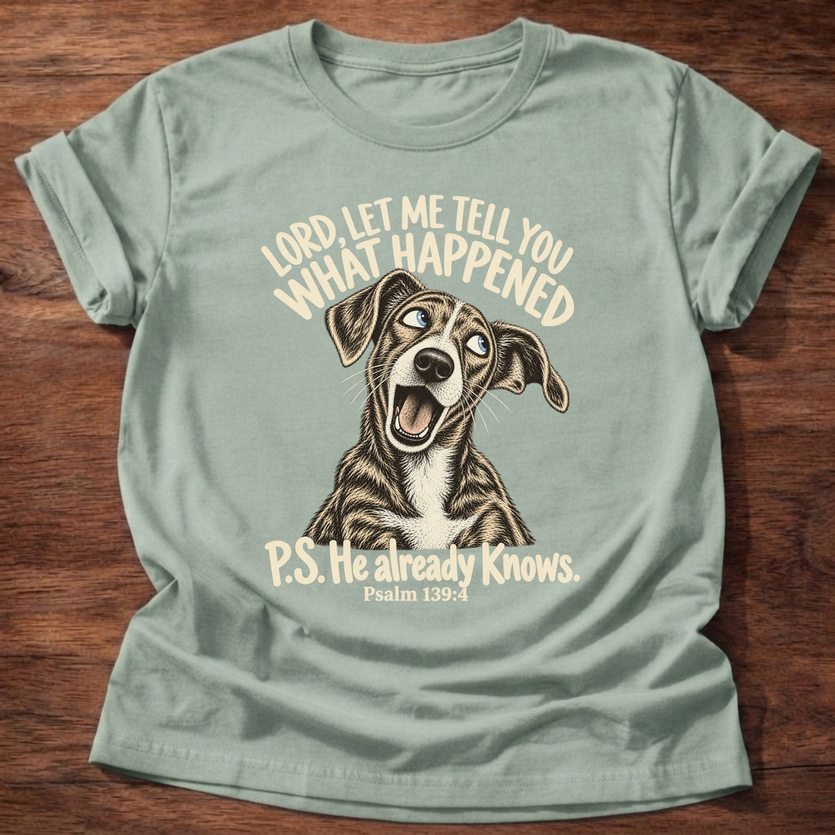 Sage t-shirt printed with a wide-eyed storytelling dog graphic and “Lord, let me tell you what happened. P.S. He already knows.” Psalm 139:4 Christian shirt
