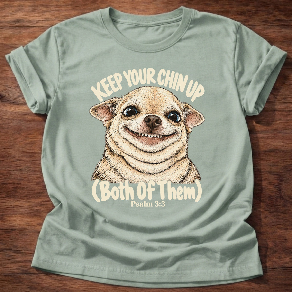 Sage t-shirt printed with a grinning fluffy chihuahua graphic and “Keep your chin up. (Both of them.)” Psalm 3:3 Christian shirt