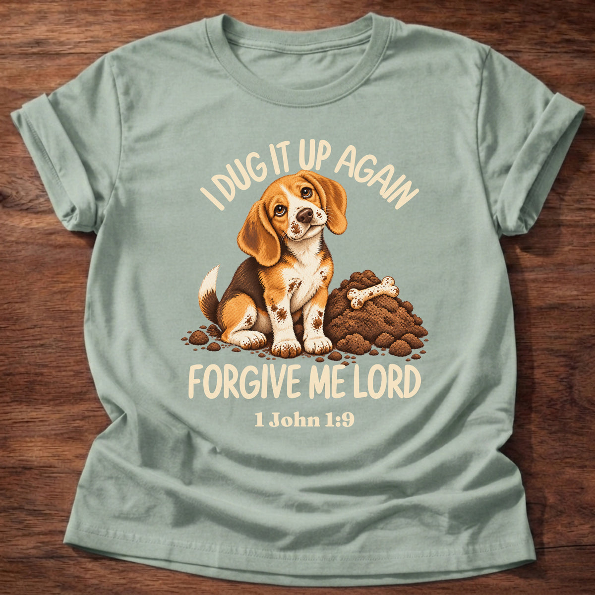 Sage t-shirt printed with a sheepish beagle puppy beside a pile of dug-up dirt and a bone and “I dug it up again. Forgive me, Lord.” 1 John 1:9 Christian shirt