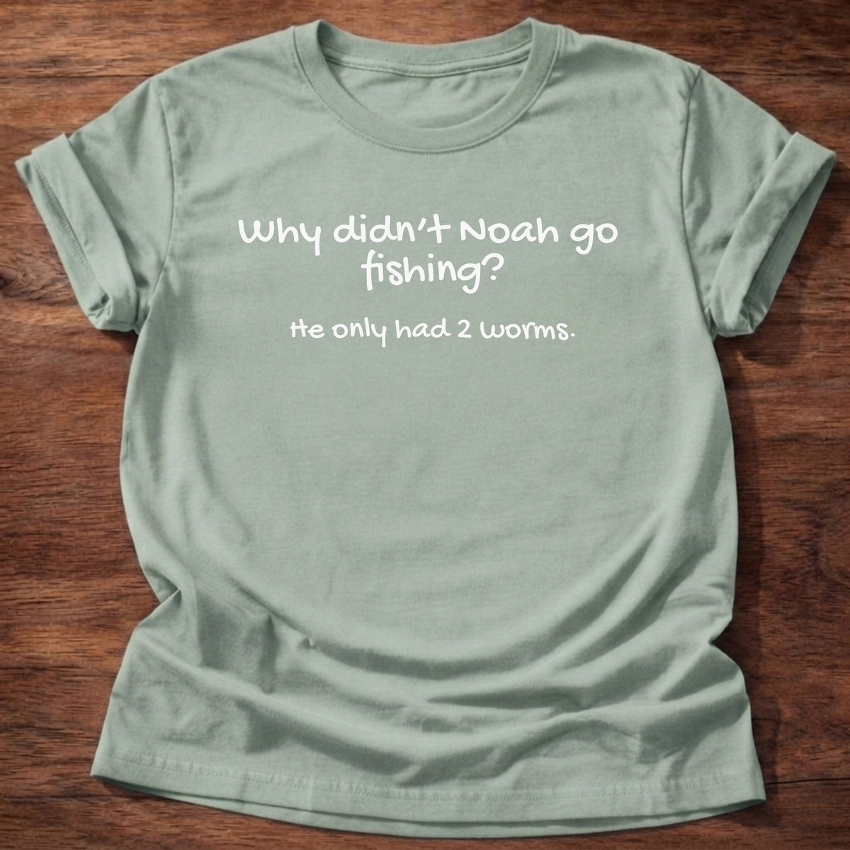 Sage t-shirt printed with a simple hand-lettered Bible joke graphic and “Why didn't Noah go fishing? He only had 2 worms.” Genesis 7:9 Christian shirt