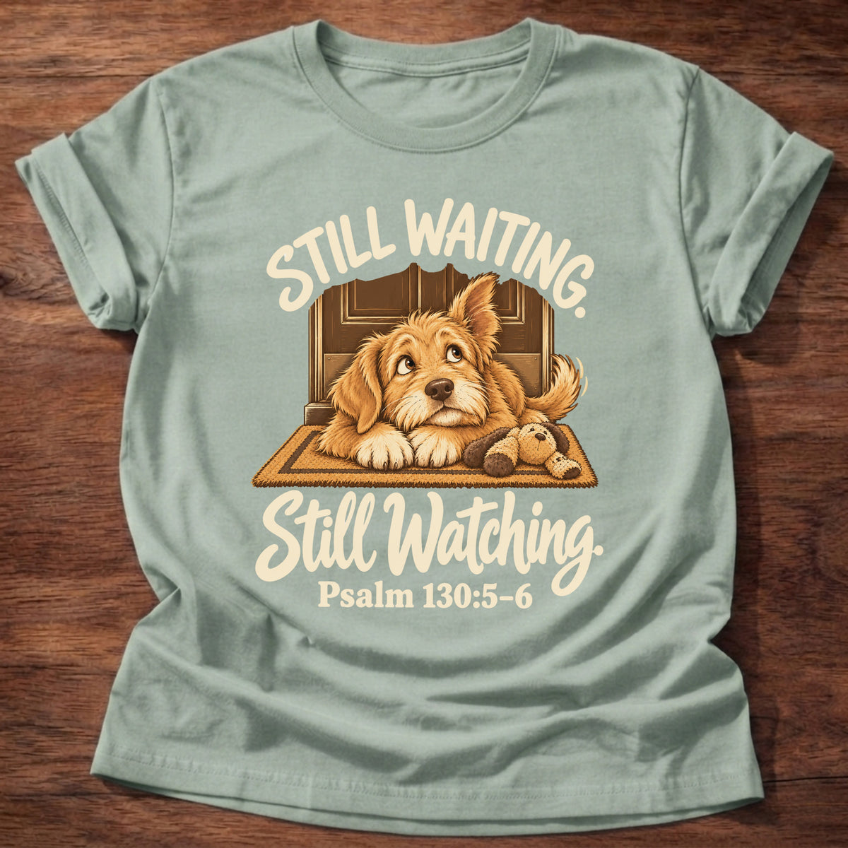 Sage t-shirt printed with a puppy lying on a doormat waiting at the door and “Still waiting. Still watching.” Psalm 130:5-6 Christian shirt