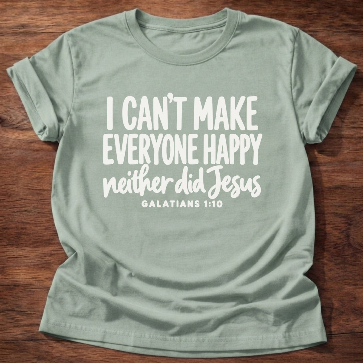 Sage t-shirt printed with bold hand-lettered typography graphic and “I can't make everyone happy. Neither did Jesus.” Galatians 1:10 Christian shirt