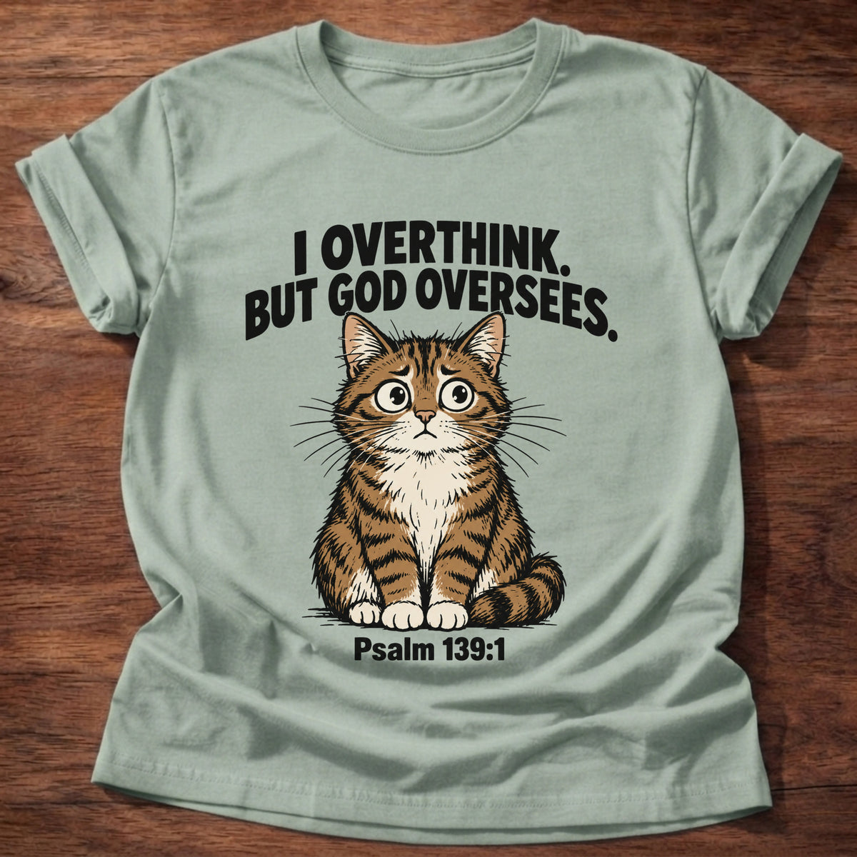 Sage t-shirt printed with a cat graphic and 'I overthink. But God oversees.' Psalm 139:1 faith based gift