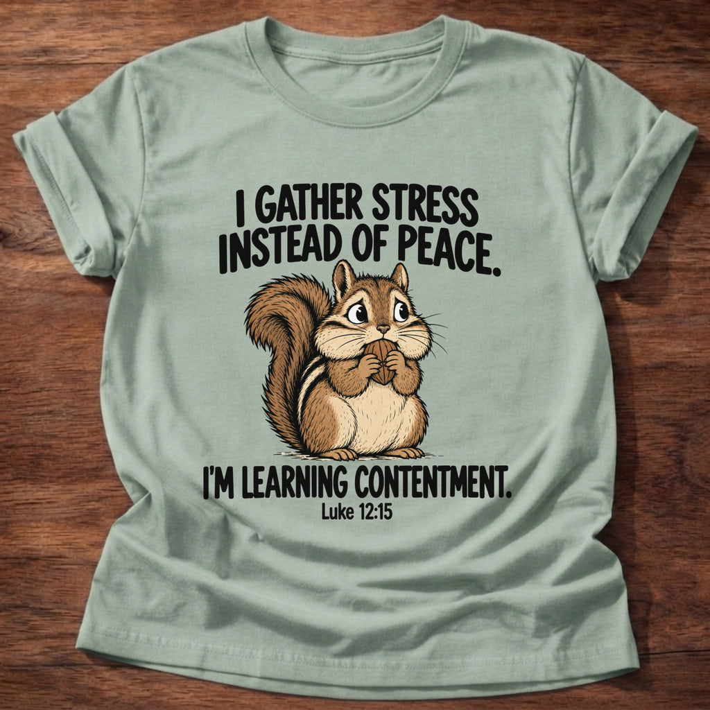 Sage t-shirt printed with a squirrel gathering acorns graphic and 'I gather stress instead of peace. I'm learning contentment.' Luke 12:15 faith based gift